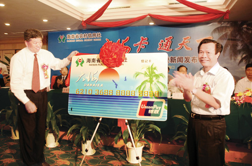 2008年4月10日，海南省副省长陈成（右）为农信社第一张大海卡揭牌